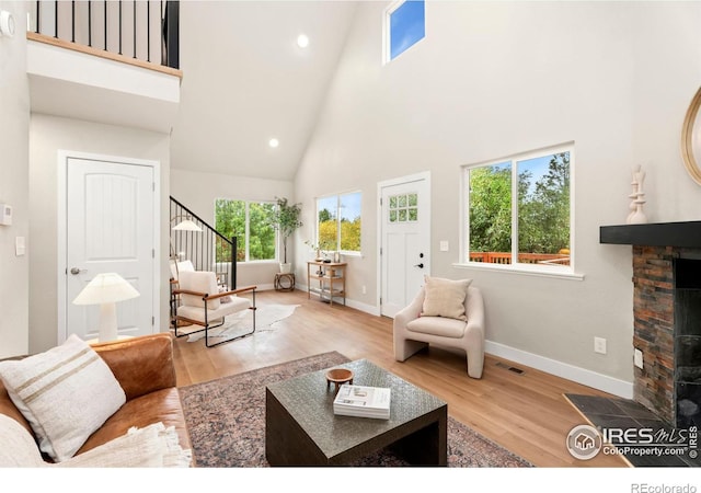 living room with a towering ceiling and light wood-type flooring