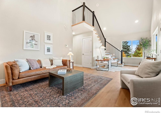 living room featuring a high ceiling and light hardwood / wood-style floors