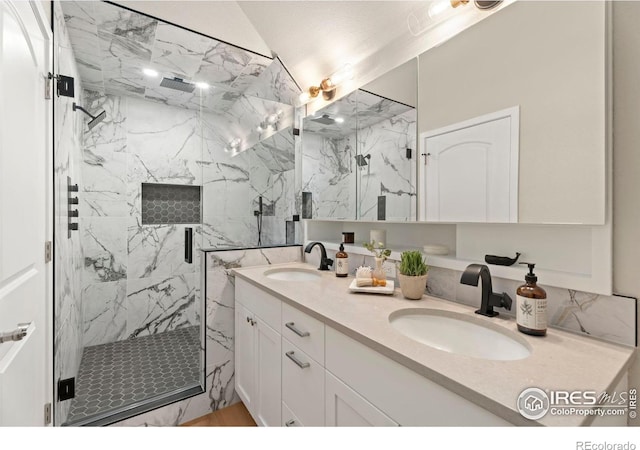 bathroom with lofted ceiling, a shower with door, and vanity