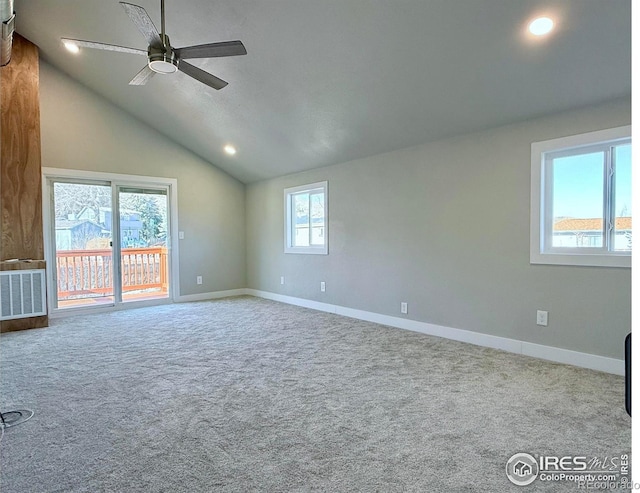 unfurnished living room with vaulted ceiling, ceiling fan, light carpet, and plenty of natural light