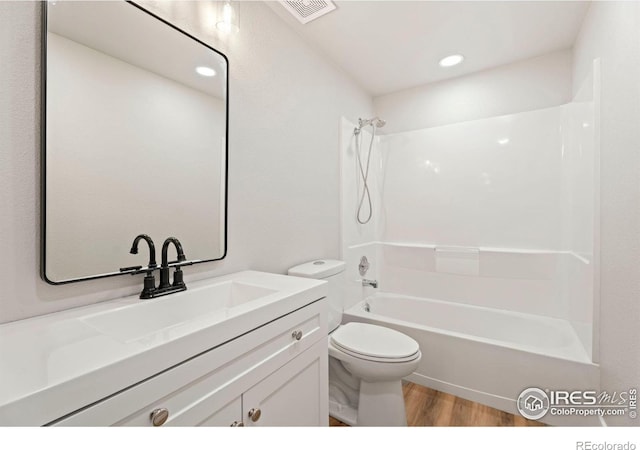 full bathroom featuring toilet, shower / washtub combination, vanity, and hardwood / wood-style floors