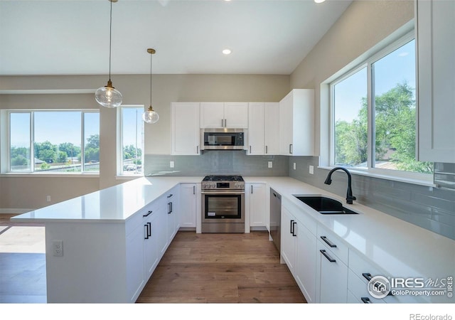 kitchen with white cabinets, decorative backsplash, sink, and stainless steel appliances