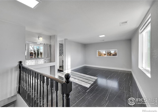 interior space featuring plenty of natural light and a textured ceiling