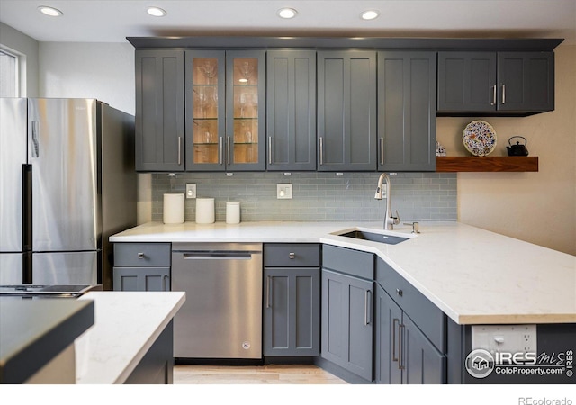 kitchen with gray cabinets, decorative backsplash, sink, and stainless steel appliances