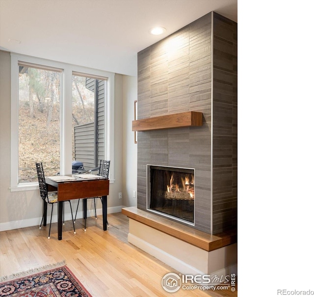 interior space with a tile fireplace and hardwood / wood-style floors