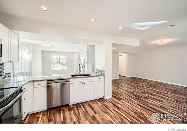 kitchen with light stone countertops, sink, stainless steel appliances, dark hardwood / wood-style flooring, and white cabinets