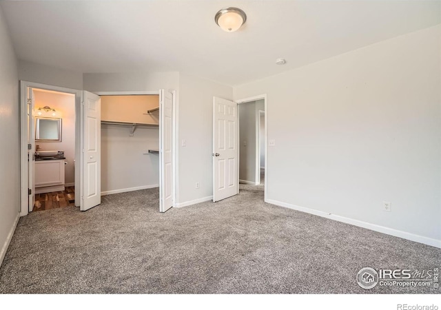 unfurnished bedroom with carpet flooring, ensuite bath, a walk in closet, and a closet