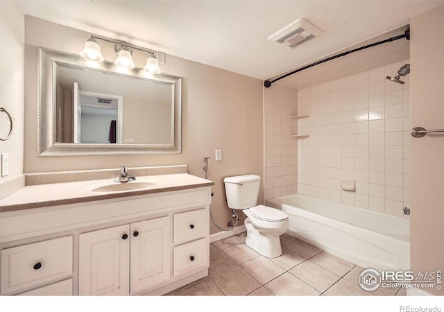 full bathroom featuring tile patterned floors, vanity, a textured ceiling, tiled shower / bath combo, and toilet