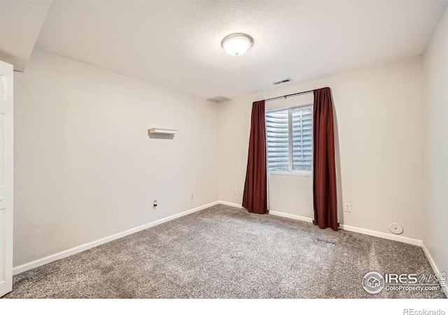 carpeted empty room with a textured ceiling