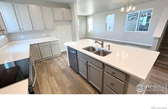 kitchen with a sink, range with electric cooktop, gray cabinets, and dishwasher