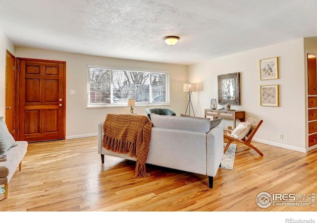 living room featuring a textured ceiling and light wood-type flooring