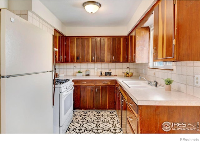 kitchen featuring white appliances, tasteful backsplash, and sink