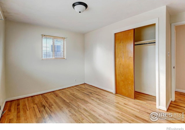 unfurnished bedroom with light hardwood / wood-style flooring and a closet