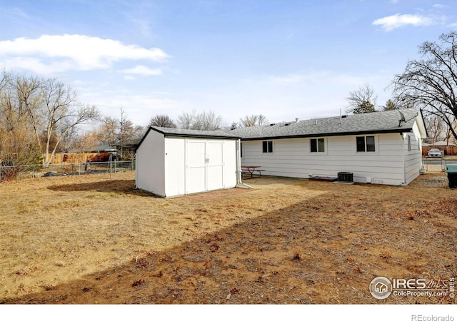 back of property featuring a storage shed and central air condition unit