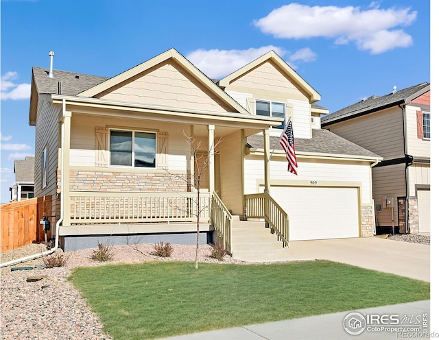 view of front of property with a porch, a front yard, a garage, stone siding, and driveway