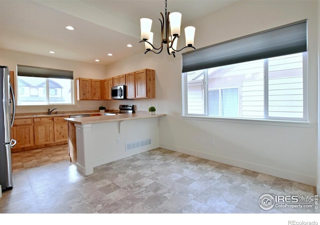 kitchen featuring visible vents, baseboards, light countertops, a peninsula, and stainless steel appliances