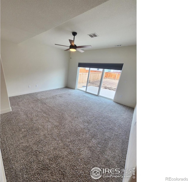 carpeted empty room featuring visible vents, a textured ceiling, a ceiling fan, and vaulted ceiling