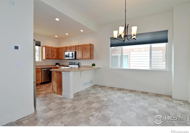 kitchen featuring visible vents, a chandelier, light countertops, a peninsula, and stainless steel appliances