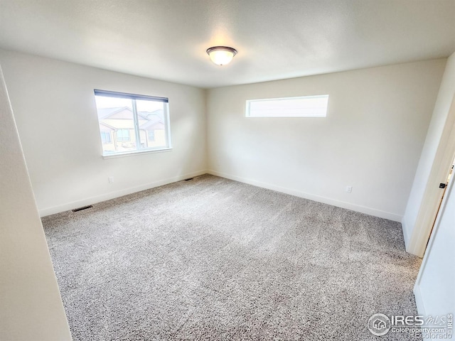 unfurnished bedroom featuring visible vents, multiple windows, and baseboards