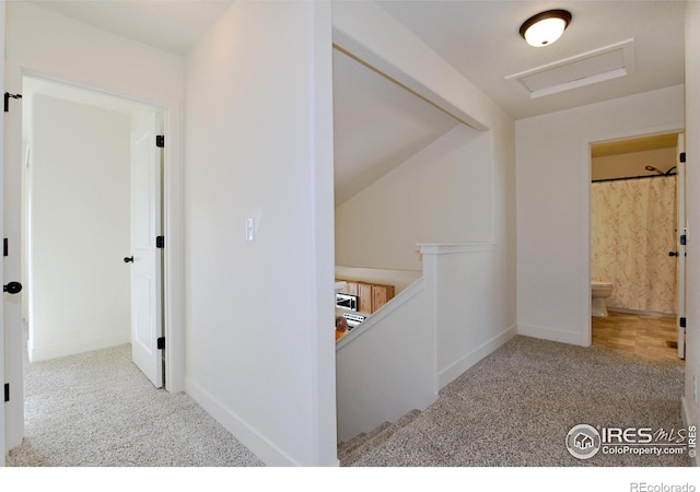 corridor with baseboards, an upstairs landing, carpet, and attic access