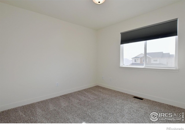 carpeted empty room with visible vents and baseboards