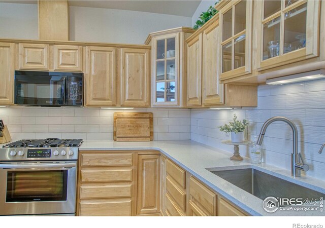 kitchen featuring decorative backsplash, high end stainless steel range, light brown cabinets, and sink