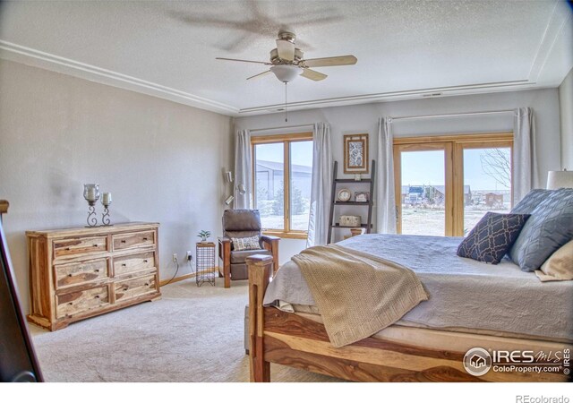 bedroom featuring multiple windows, ceiling fan, light carpet, and a textured ceiling