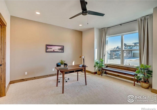 carpeted office space featuring ceiling fan