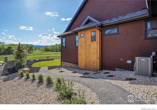 view of side of home with a lawn and central air condition unit