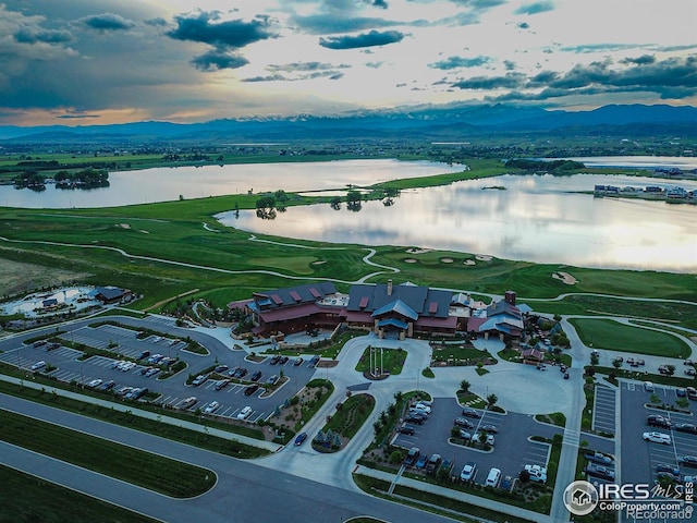 aerial view at dusk featuring a water view