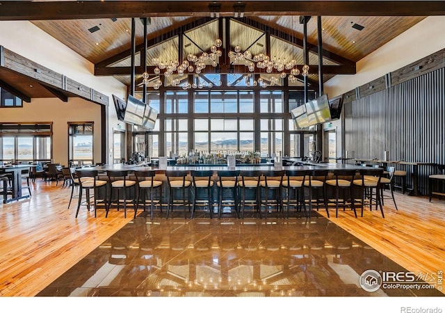 bar featuring beam ceiling, wooden ceiling, and high vaulted ceiling