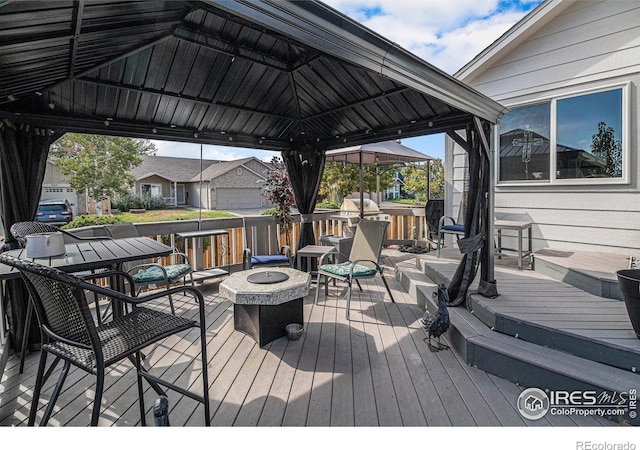 deck featuring a gazebo and an outdoor fire pit