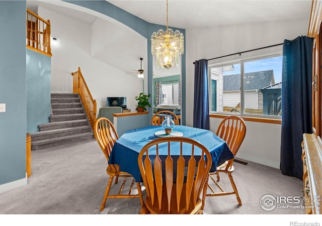 dining room with lofted ceiling, light carpet, and ceiling fan with notable chandelier