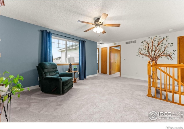 sitting room with carpet flooring, a textured ceiling, and ceiling fan