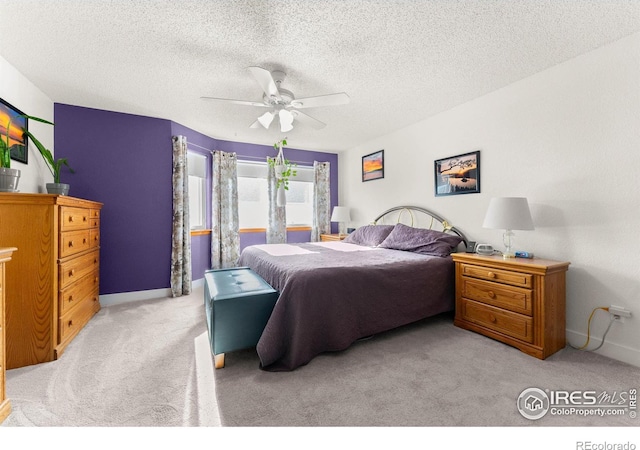 bedroom with a textured ceiling, ceiling fan, and light carpet