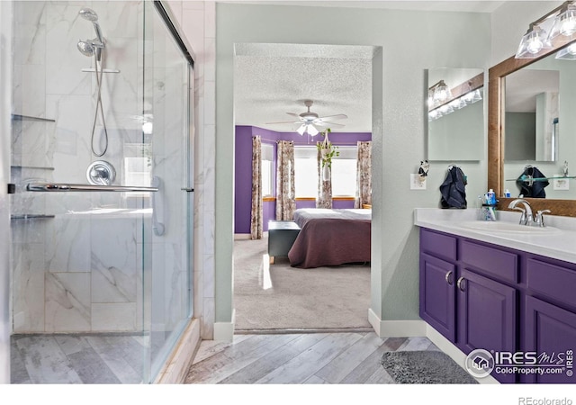 bathroom featuring vanity, a textured ceiling, a shower with door, and ceiling fan