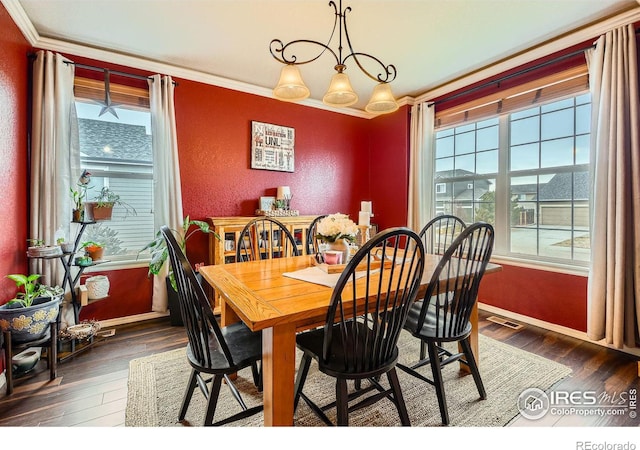 dining room with dark hardwood / wood-style floors and crown molding