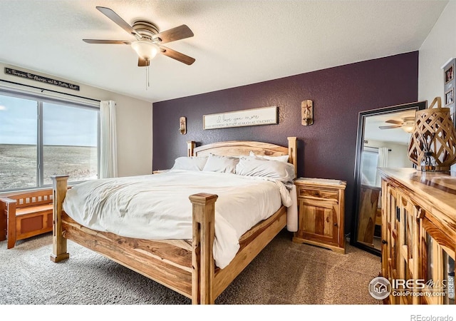 carpeted bedroom with a textured ceiling, a water view, and ceiling fan