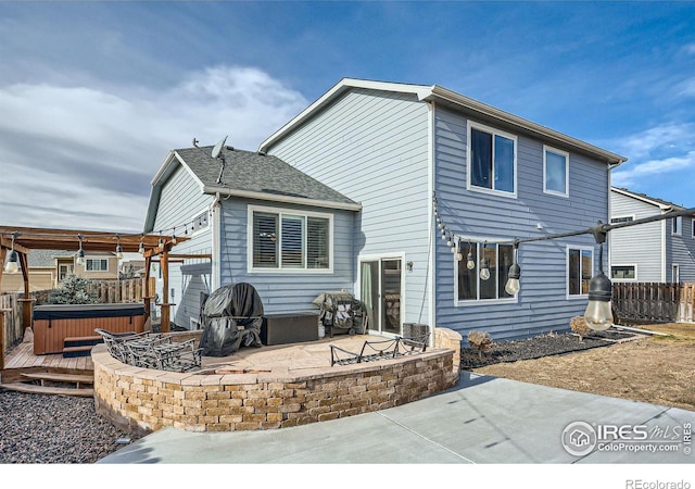 back of house with a patio area, a pergola, and a hot tub