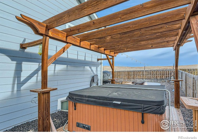 wooden terrace with a pergola and a hot tub