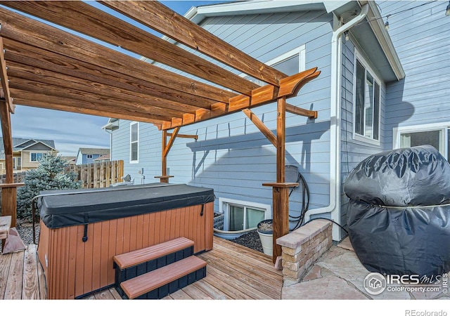 deck featuring a pergola and a hot tub