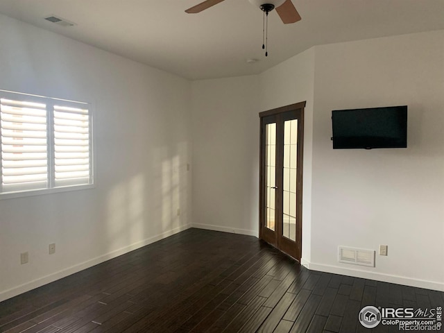 empty room featuring dark hardwood / wood-style floors, ceiling fan, and french doors