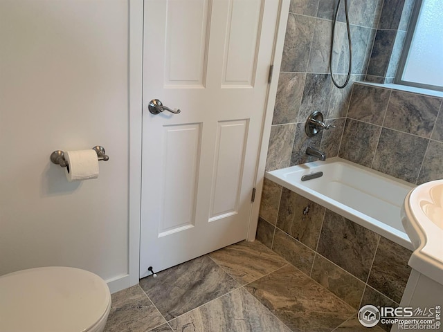 bathroom featuring toilet and tiled shower / bath combo