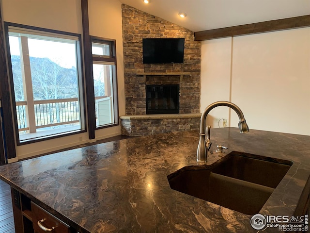 kitchen with lofted ceiling with beams, a healthy amount of sunlight, dark hardwood / wood-style flooring, and sink