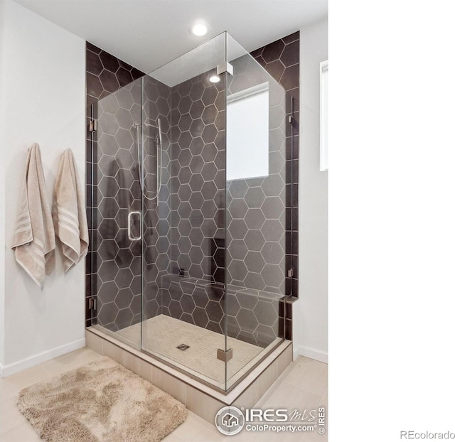 bathroom with tile patterned flooring and a shower with door