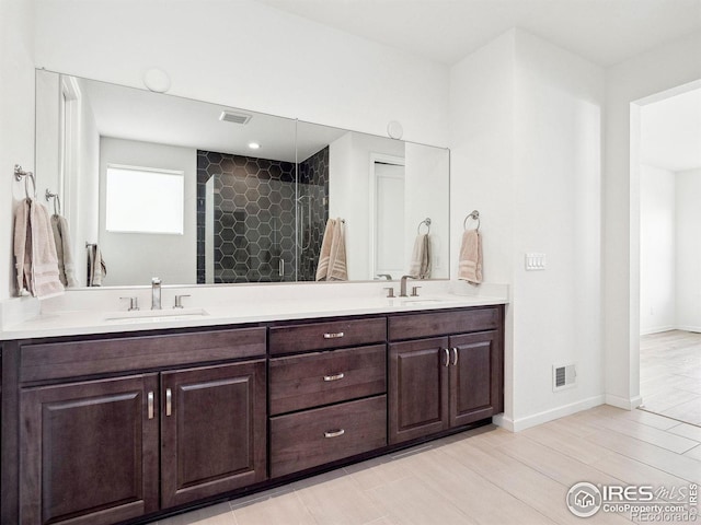 bathroom featuring a tile shower and vanity