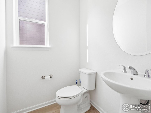 bathroom with hardwood / wood-style flooring, toilet, and sink