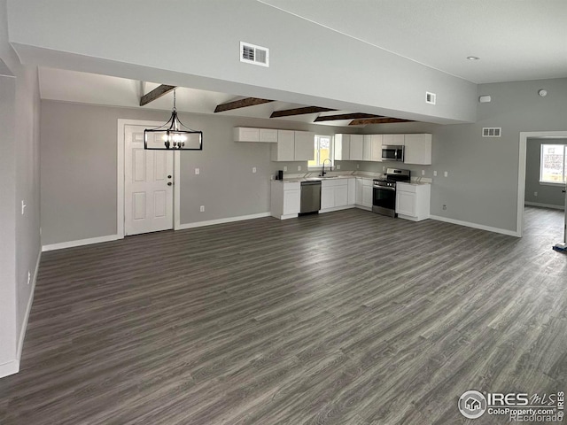 unfurnished living room with a chandelier, lofted ceiling with beams, and dark hardwood / wood-style floors