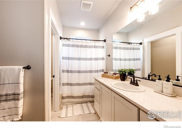 bathroom featuring vanity, tile patterned floors, and walk in shower