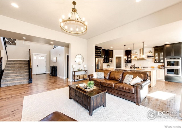 living room featuring a notable chandelier and light hardwood / wood-style floors